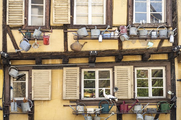 Half-timbered house decorated with watering cans in the old town of Colmar