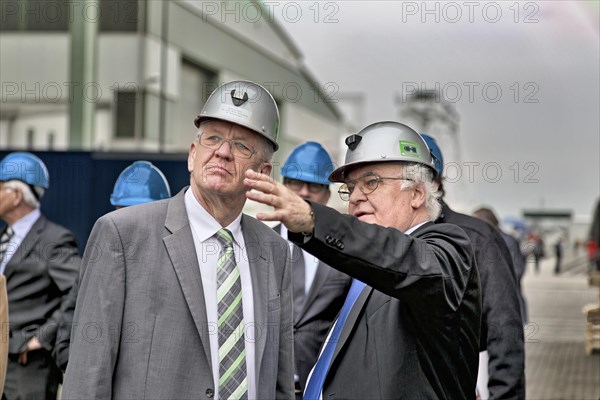 Minister President Winfried Kretschmann with Martin Herrenknecht - both wearing safety helmets - during a visit to Herrenknecht AG