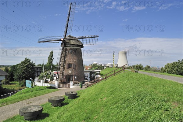 The windmill Scheldedijkmolen and cooling towers of the Doel Nuclear Power Station along the river Scheldt at Kieldrecht