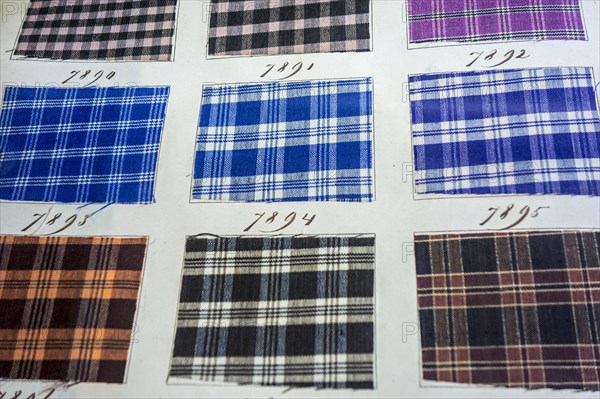 Page in old textile sample book showing chequered fabric samples with different weaving patterns and colour combinations