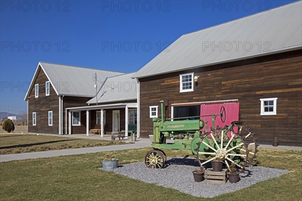 Vintage 1930s John Deere tractor in front of traditional Mennonite dairy farm of Mennonites living in Cuauhtémoc