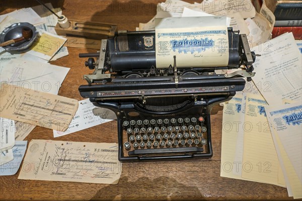 Vintage early 20th century American Underwood Standard Typewriter with wide carriage and old 1920s documents on antique office desk