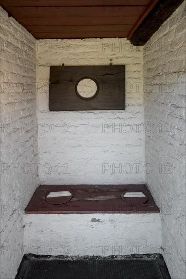 Old farm's stone outhouse with two-seater pit latrine