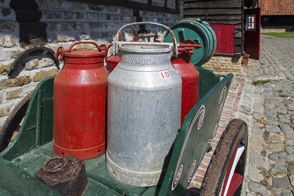 Antique handcart loaded with old metal milk churns