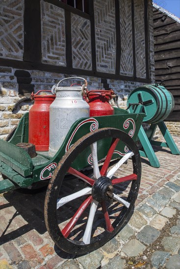 Antique handcart loaded with four old metal milk churns