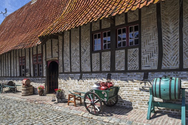 Antique handcart with milk churns and vintage barrel-type butter churn at the open air museum Bachten de Kupe