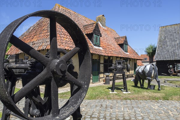 17th century farmhouse and antique agricultural machines at the open air museum Bachten de Kupe