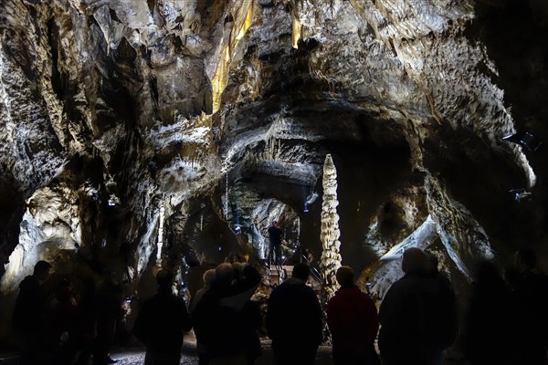 Tourists looking at big stalagmite during guided tour in the Caves of Han-sur-Lesse