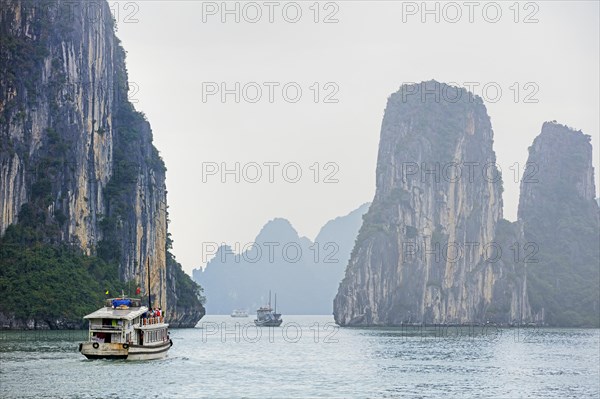 Tourist boats and limestone monolithic islands in Ha Long Bay