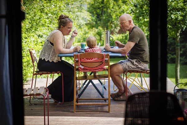 Family sitting together on the terrace having a meal