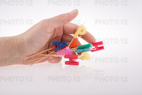 Letters made of candles on sticks falling off hand