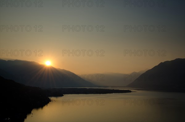 Sunrise over the mountain and alpine lake Lago Maggiore