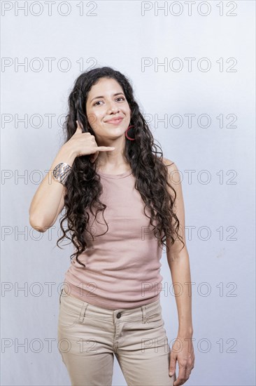 Young woman making phone gesture with fingers. Young girl making phone gesture isolated