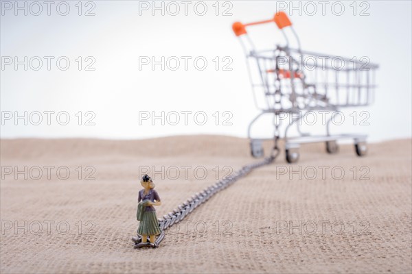 Woman figurine attached to a Shopping cart with chain