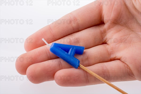 Color candle in hand on sticks writes the letterA