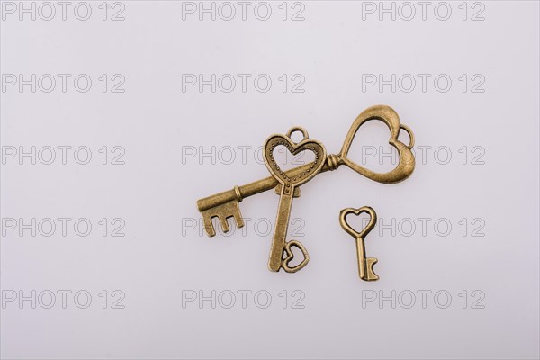 Heart shaped retro metal keys on white background