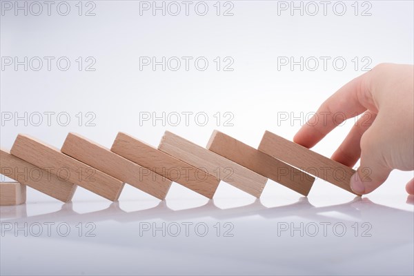 Hand holding wooden domino on a white background