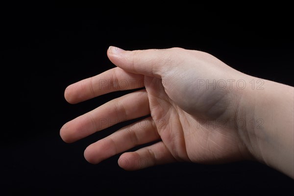 Five fingers of a child hand partly seen in black background