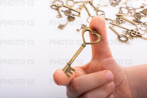 Hand and retro style metal keys on a white background