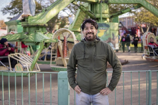 Portrait of latino man posing happy in an amusement park