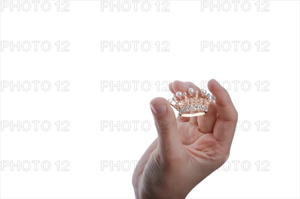 Golden color crown with pearls in hand on a white backgound