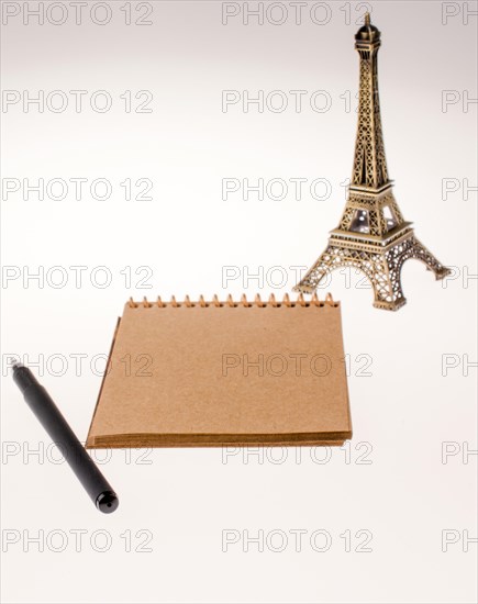 Notebook and pen with Eiffel Tower on the background