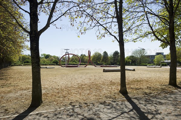 Withered meadow and sculpture of a water tap