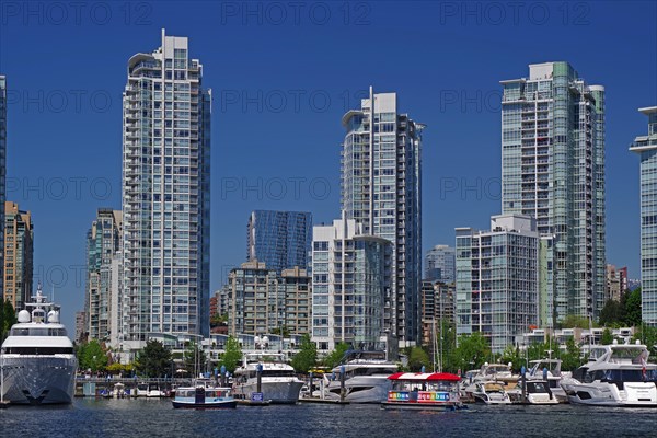 Small boats and yachts in front of skyscraper canyons