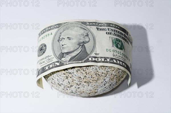 The Bill of Ten Dollar Lying on a Stone with White Background