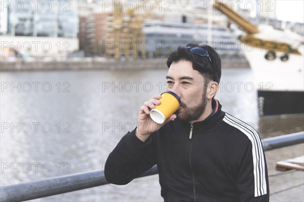 Latin tourist drinking coffee at an outdoor bar in Puerto Madero