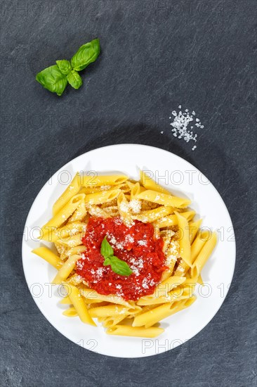 Penne Rigatoni Rigate Italian pasta in tomato sauce eat lunch dish on plate slate from above in Stuttgart