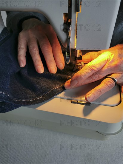 Hands of woman with a sewing machine