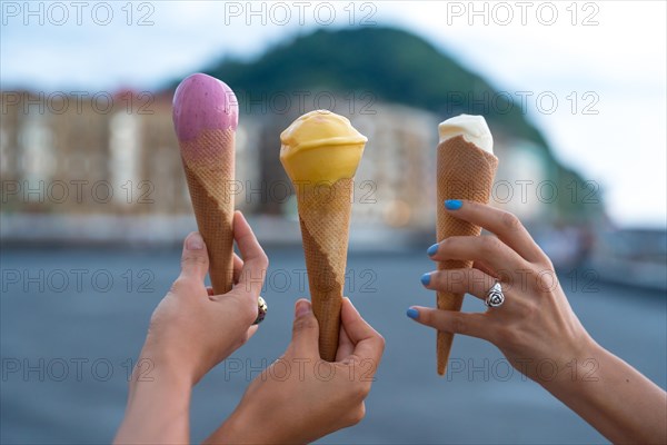 Hands of a young female friends eating a strawberry