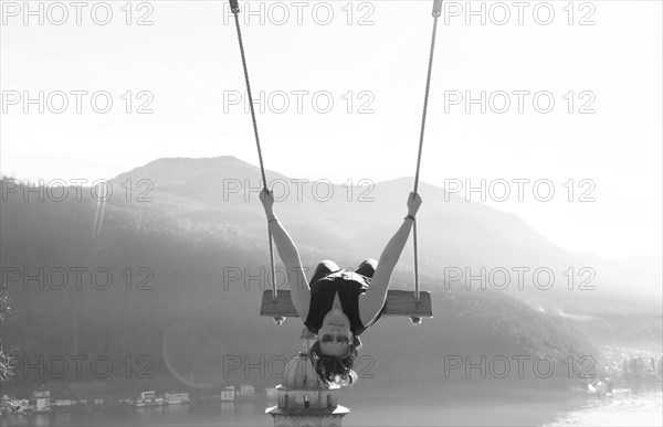 Woman on a Swing with Mountain View and Sunlight over Lake Lugano in Morcote