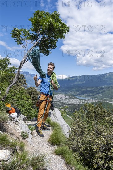 Climber throws climbing rope over his shoulder