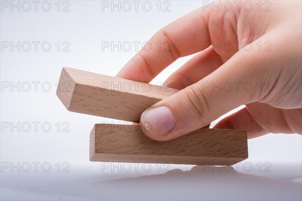 Hand holding wooden domino on a white background