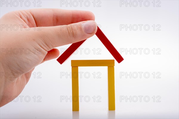 Hand holding domino pieces forming a house shape