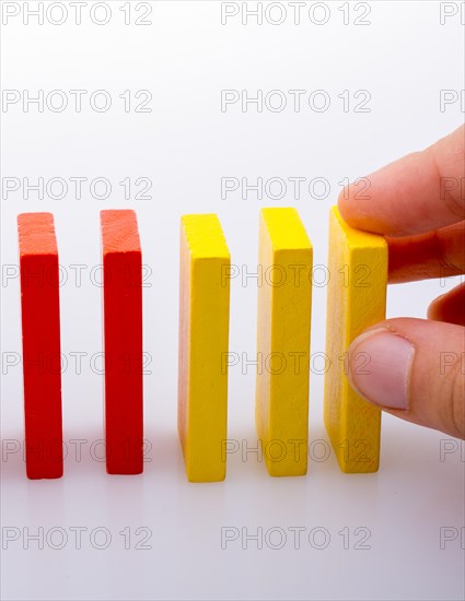 Hand holding color dominoes on a white background