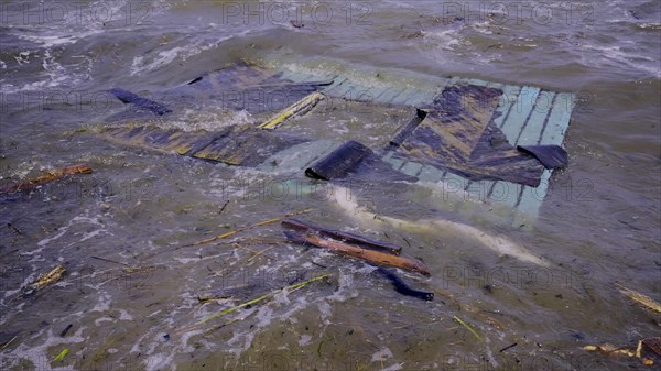 Part of wall of house floats near shore