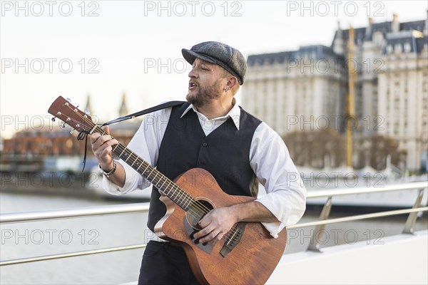 A street musician performing classic songs while playing guitar