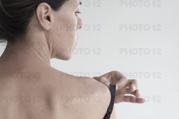 Woman holding her bra in profile