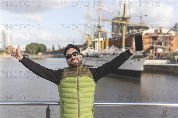 Happy tourist posing in front of a boat in Puerto Madero