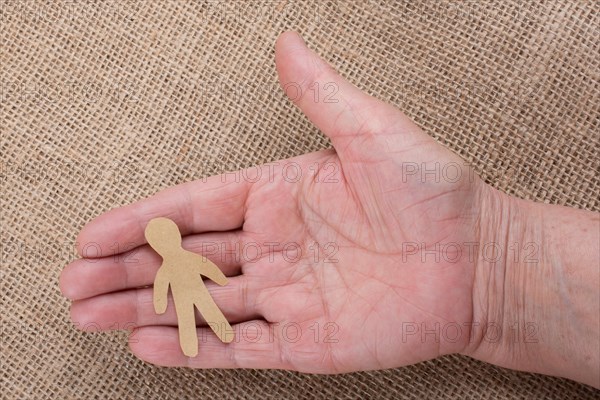 Man shape cut out of paper in hand in the view