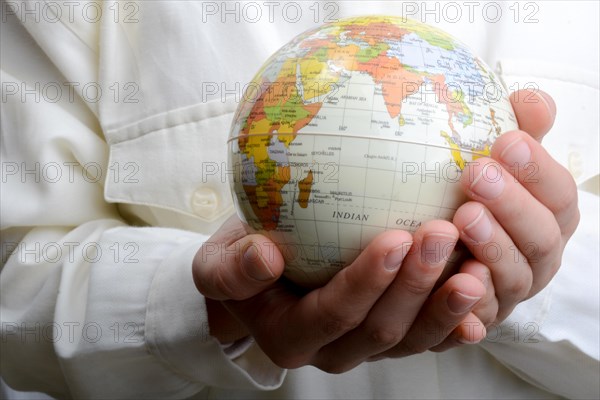 Child holding a small model globe in hand on white background