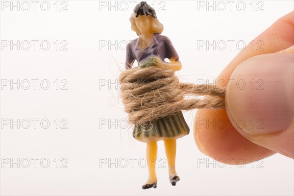 Woman figure in hand tied with a linen thread on a white background