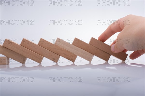 Hand holding wooden domino on a white background