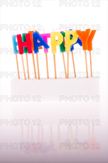Color candles on sticks write the word happy