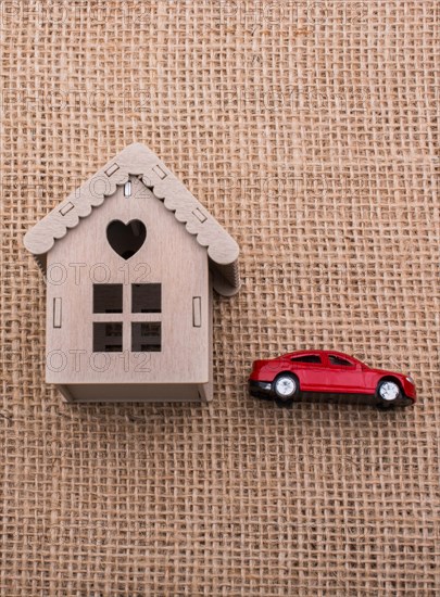 Model car and a little model house on a canvas background