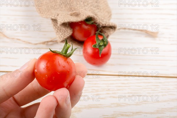 Little canvas sack and red ripe tasty fresh cherry tomatos