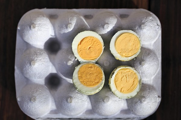 Cooked halved quail eggs on an egg carton